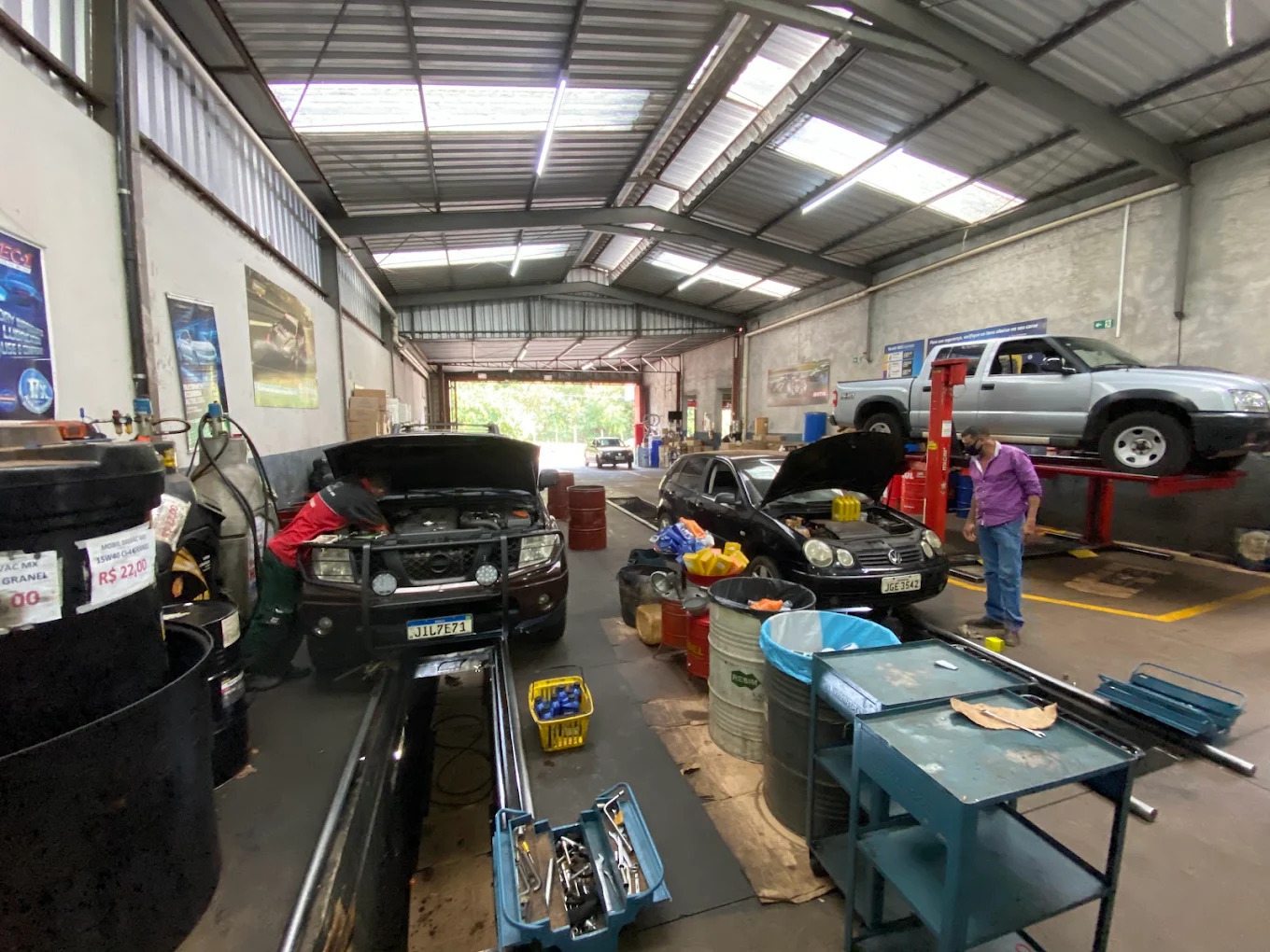 Interior da oficina Rei do Óleo em Uberaba, com veículos em atendimento e equipe trabalhando